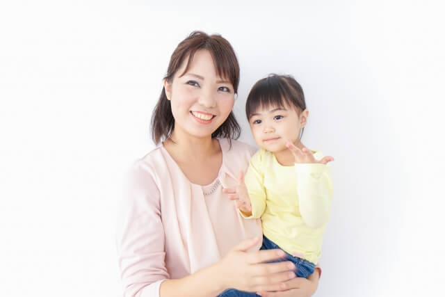 笑顔で子どもを抱っこする保育士