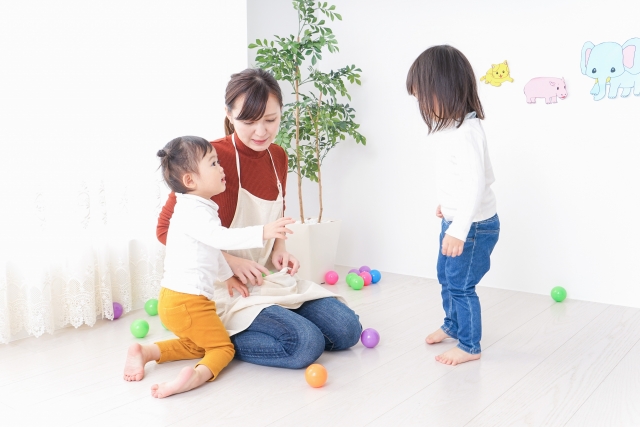 綺麗な保育室で子どもと遊ぶ保育士