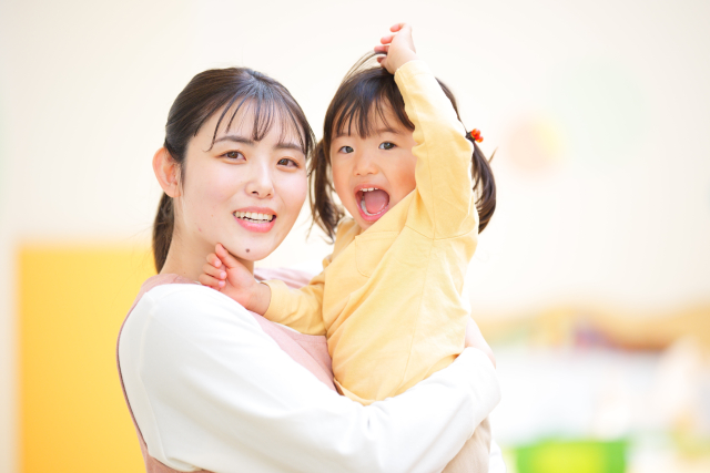 子どもを抱っこする保育士